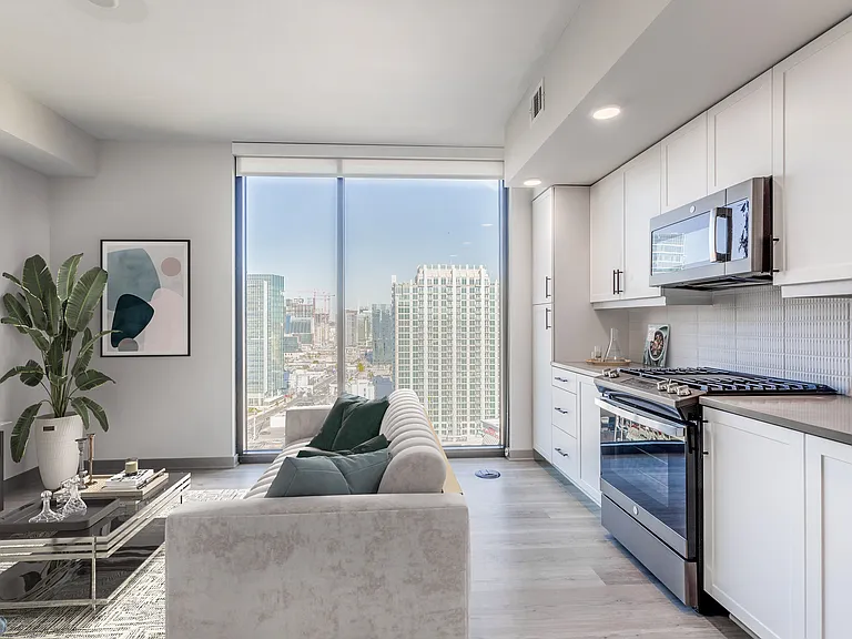 Studio Living Area and Kitchen with Floor to Ceiling Windows and Views of the City