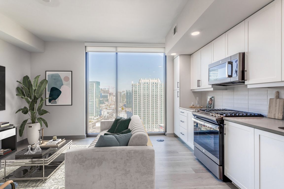 Studio Living Area and Kitchen with Floor to Ceiling Windows and Views of the City