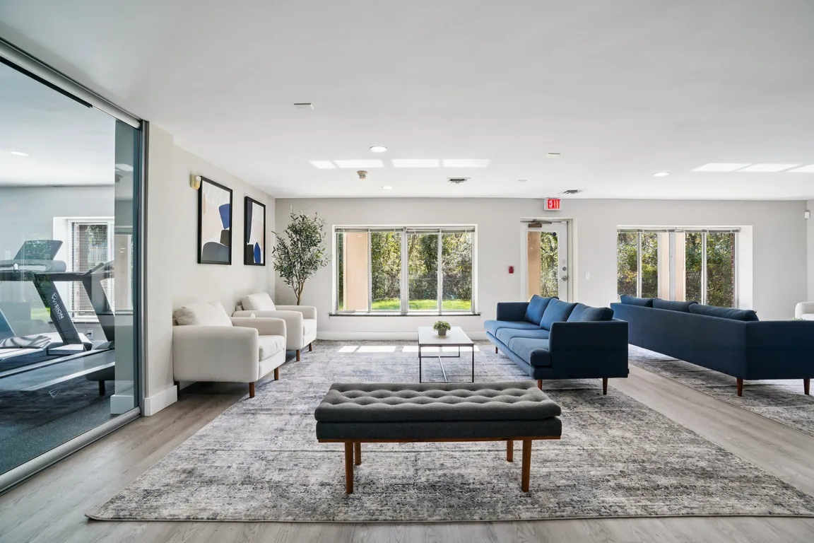 Relax in our modern community room with large windows offering scenic tree views, professionally operated by Highlands Vista Group.