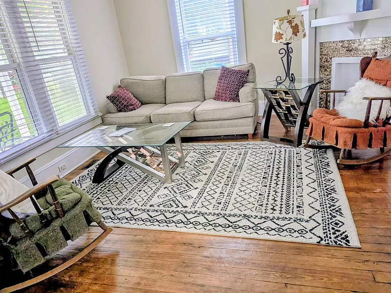 Inviting living room with large windows, comfortable seating, and a fireplaceideal for relaxing or entertaining.