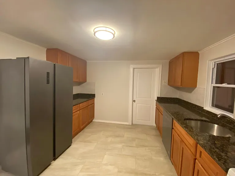 large kitchen with granite counter tops, stainless steel appliances, ceramic tiled backsplash and tiled floors