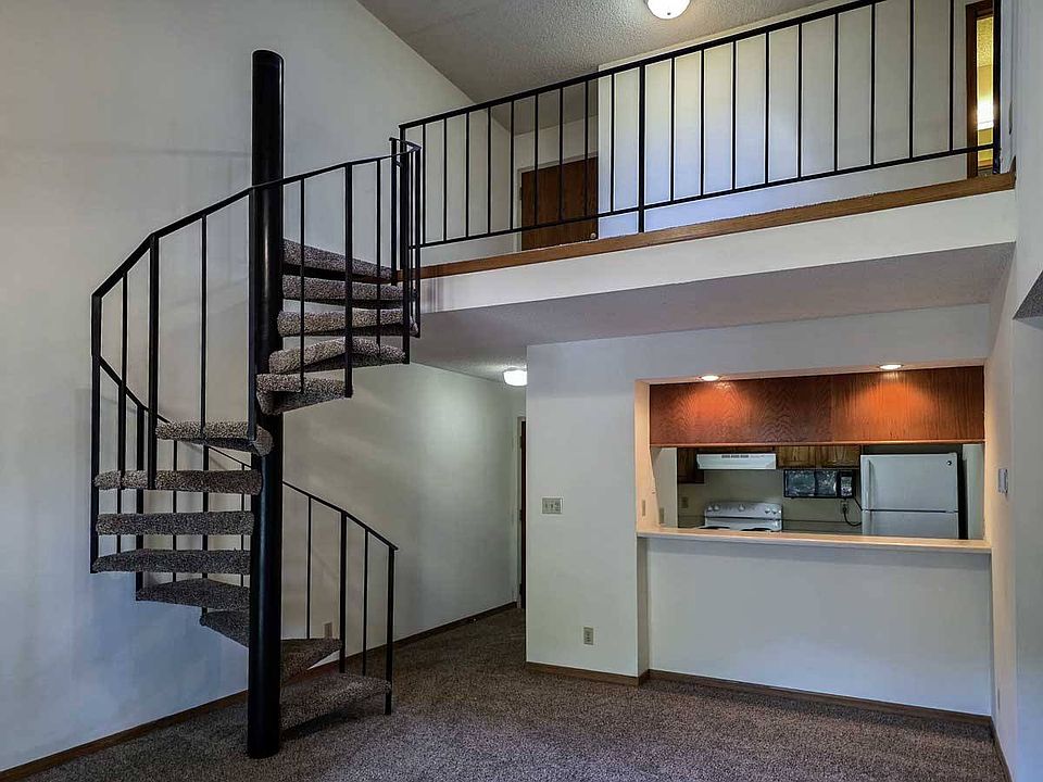 An open living area with a unique spiral staircase adds charm and function.