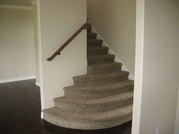 Curving foyer stairway and Indonesian teakwood floor.