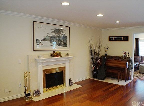 inviting LIVING ROOM- marble enclosed FIREPLACE with decorated wood mantel piece, Brazilian Cherry h