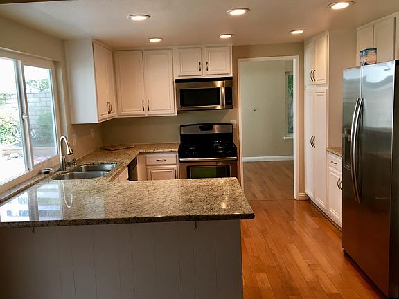 Wrap around granite counter with breakfast bar. Easy flow to rest of house. Kitchen has 6 recessed lights that can be dimmed. Open floor plan with cherry wood floor throughout.