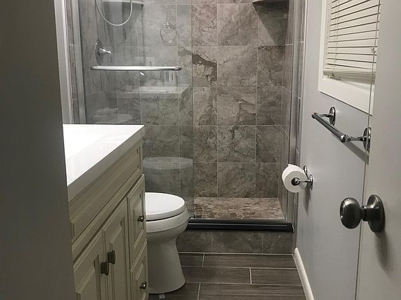 Private en suite Master bath with newly remodeled tiled shower, glass door, and vanity.