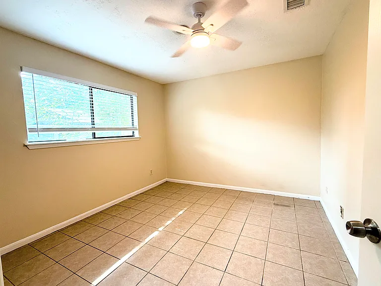 Bright and inviting bedroom with generous natural light, neutral finishes, and ample closet space.