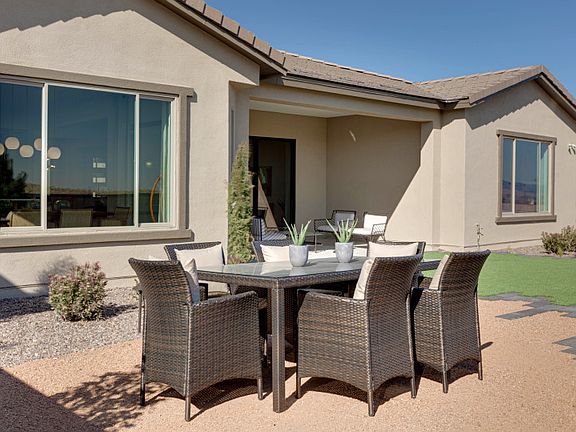 The backyard boasts ample space and is shown with an outdoor dining set for easy entertaining.
