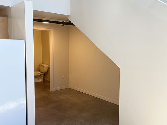 Bathroom entrance with area under stairs.