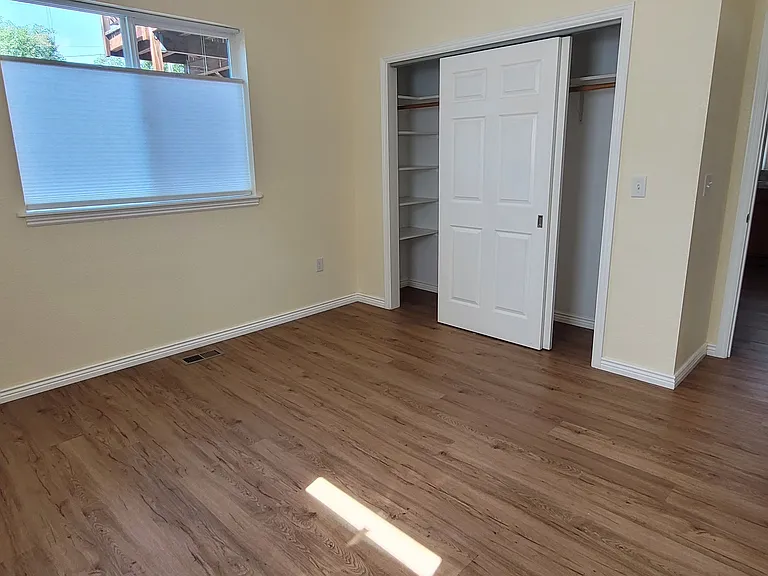 Master Bedroom with large closet with shelves at both ends and sliding closet doors
