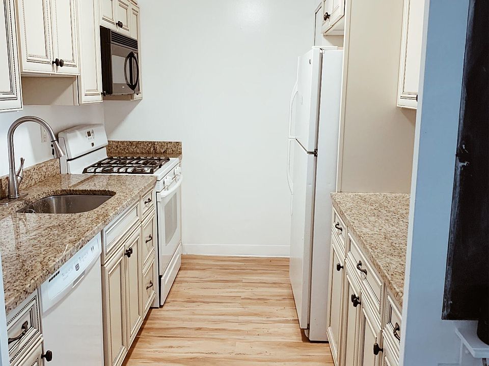 Kitchen with granite countertops, gas range & dishwasher.