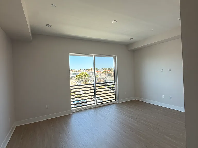 Main Living space with juliette balcony, sliding and screen door. Curtains to be installed prior to move in.
