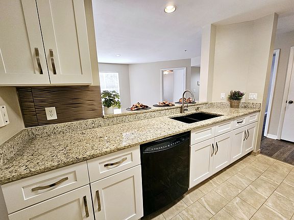 Bright kitchen with stainless steel appliances and eat in bar area open to the dining and living room.