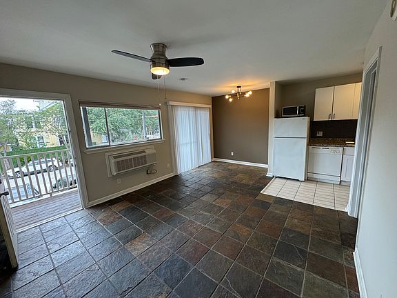 View from corner of the living room towards breakfast area and kitchen. Note accent wall and sliding glass door.