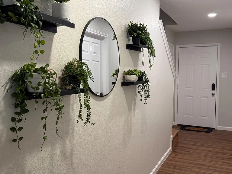 Welcoming entry hall with wood-look flooring, recessed lighting, and accent shelving for plants and everyday essentials.
