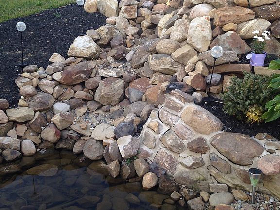 Backyard waterfall master bedroom has sliding glass door with Back attached to it