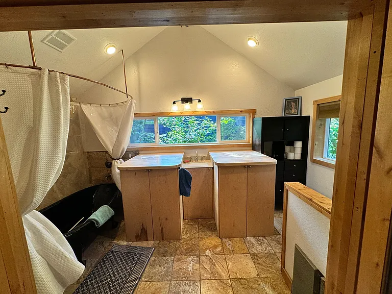 Large bathroom with hidden washer/dryer and custom clawfoot extra-large bathtub.