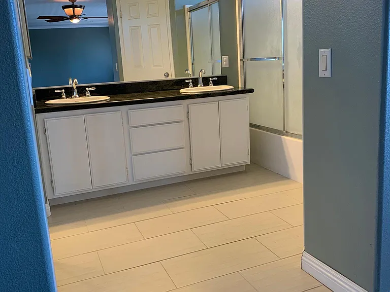 Very large master bedroom with double sinks and tile floor bathroom area.