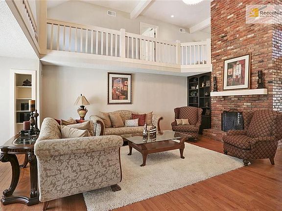 Great room with plenty of space for entertaining, focal-point fireplace opens up to loft on second level.