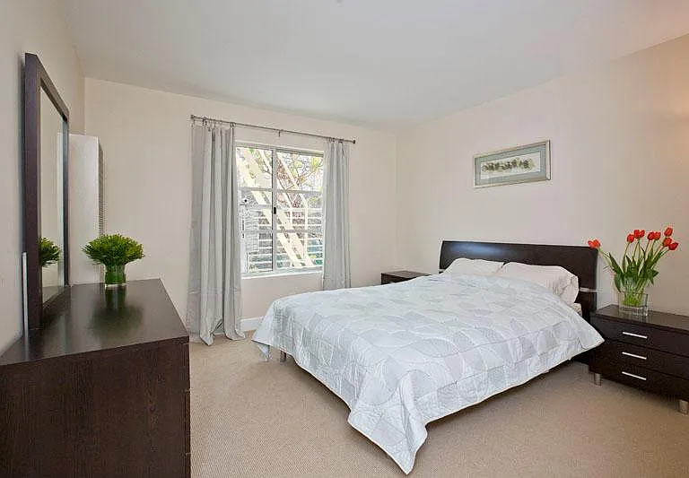 Bedroom holds king-sized bed, two nightstands, and a dresser.
