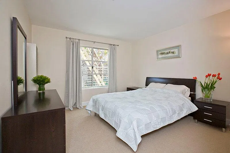 Bedroom holds king-sized bed, two nightstands, and a dresser.