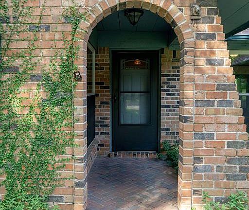 The entrance to the home is inviting, flanked by picture windows on each side.