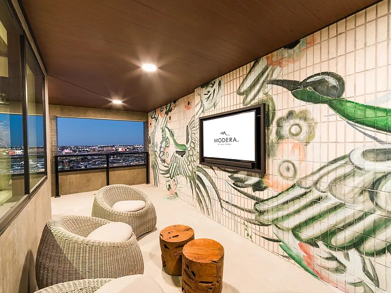 A cozy sky lounge with custom mural details and skyline views, offering a relaxed spot to unwind at Modera St. Paul.