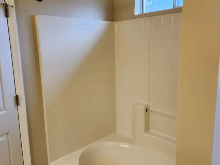 Bathtub/Shower combination; modern bronze curtain rod.