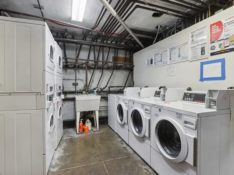 Laundry room with washing machines neatly arranged on a wooden floor