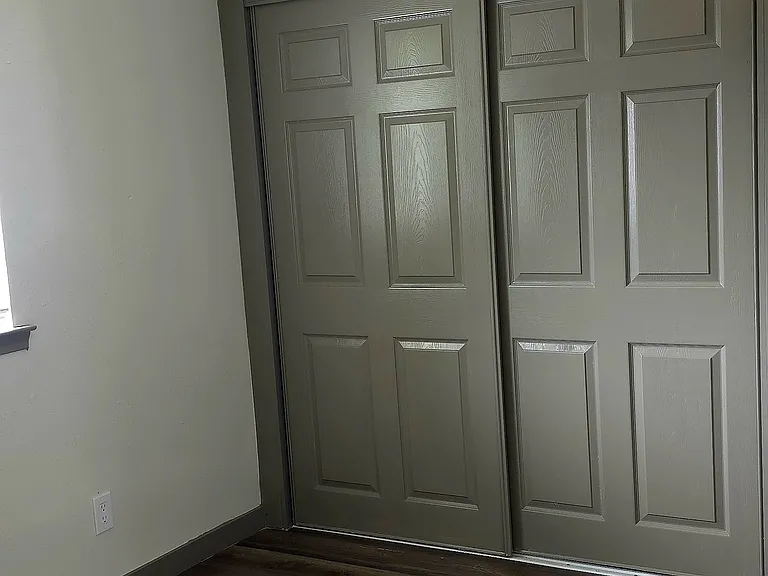 bedroom features new flooring, blinds, ceiling fan, and large closets