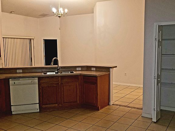 Kitchen island, breakfast bar, pantry to the right, overlooking living room area