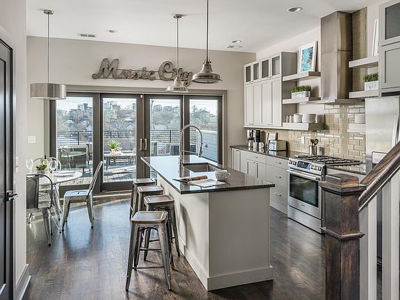 Kitchen includes a gas range, dishwasher, microwave and fridge...huge pantry on the left for storage...direct access to the first rooftop deck...the SECOND rooftop has the stairs on the right.