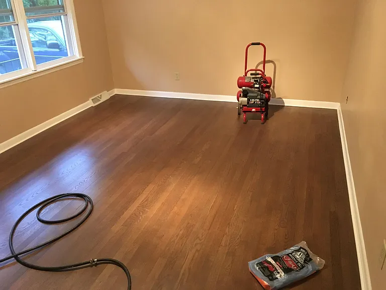 Refinished hardwood floors with freshly painted walls and trim in the living room