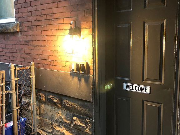 Secure main (side) entrance to 3 apartment flats. Motion detector lighting. Entrance to back Yard at left gate.