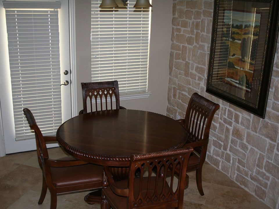 Dining area with warm stone wall and windows providing lots of natural light