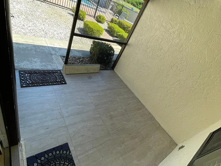 Screened lanai on front with view of community pool...