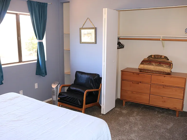 Master bedroom, other angle showing closet and dresser and leather chair.