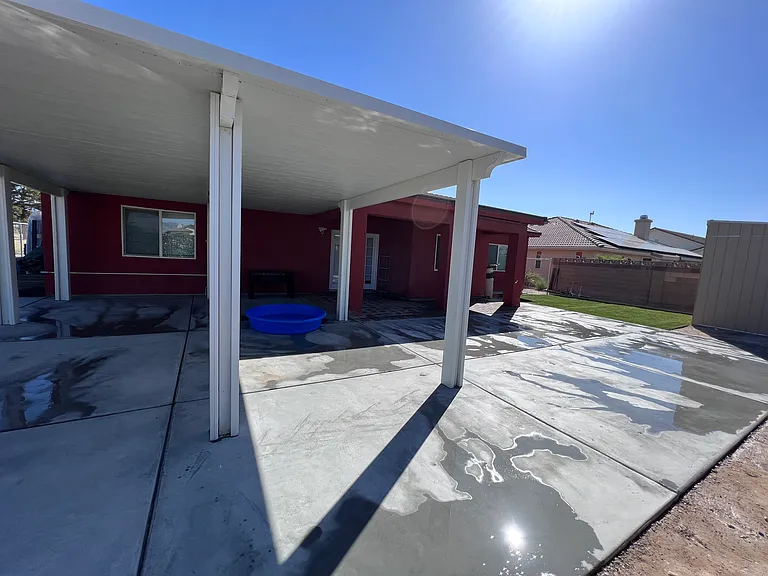 Backyard with concrete floor and patio cover to keep gatherings cooler.