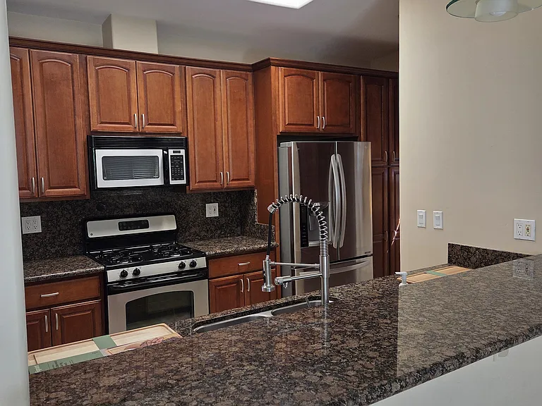 Kitchen with stainless/black appliances including fridge, microwave, gas stove and dishwasher.