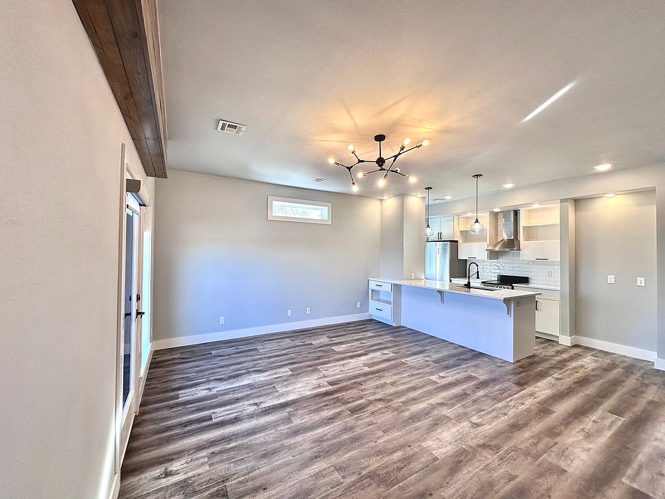 Enjoy an open layout with expansive windows, statement lighting, rich wood elements, and a versatile bar nook. There is a small flexible space next to the kitchen that can be used for a hutch or desk. Call or text for a tour today!