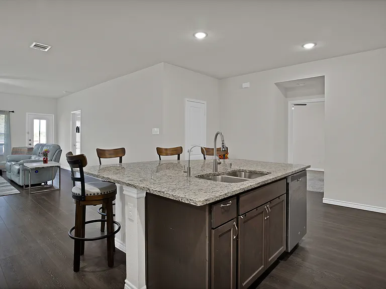 Kitchen with oversized island, stainless steel dishwasher, and sink