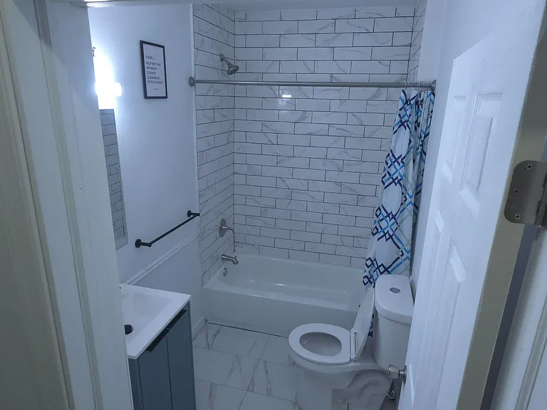 Updated full bath with a tub/shower combo, subway-tile surround, and a vanity for everyday storage.