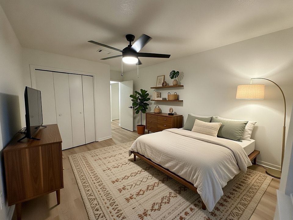 Another large bedroom off the hallway with large closet containing built in shelves and hanging racks. Large window to the right allowing ample natural light.