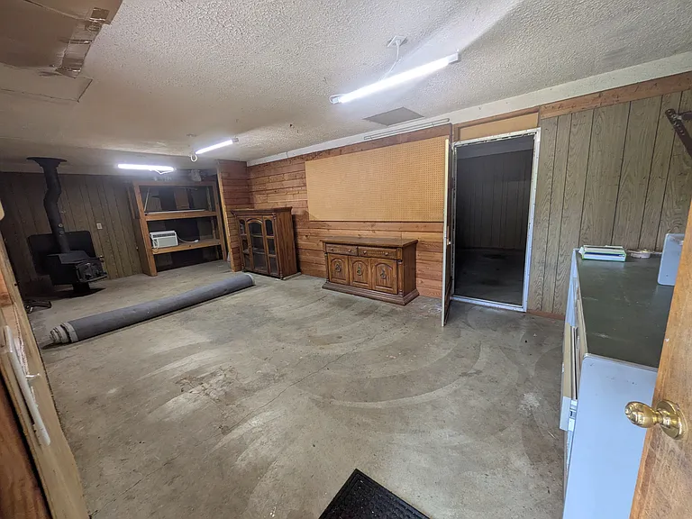 2-car garage where one stall is currently set up for a woodworking/storage space. Second stall is set up for car storage.