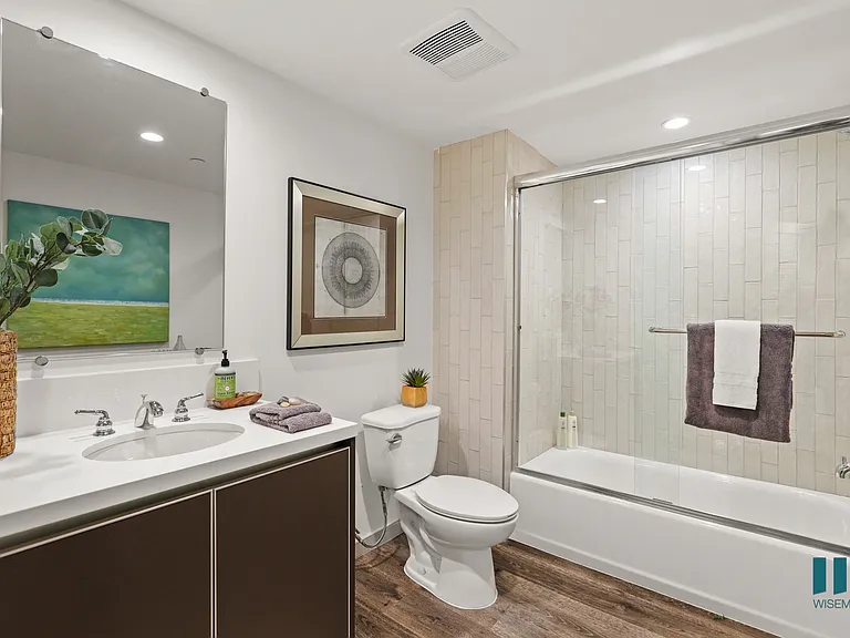 Bathroom with Full-Size Bathtub with Glass Door, and Vanity Cabinet Storage