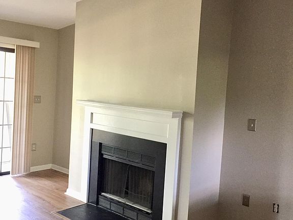 Living room w/ vaulted ceiling, electric fireplace and access to deck