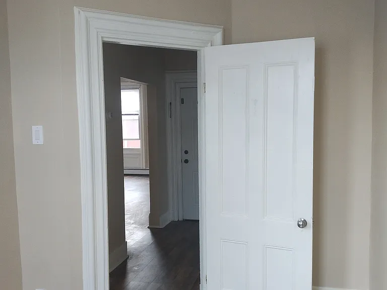 View of entry hall and front door from spare room. 

Living room window seen across hall.