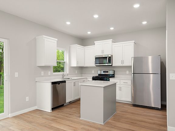 The kitchen has stainless steel appliances and white cabinets.