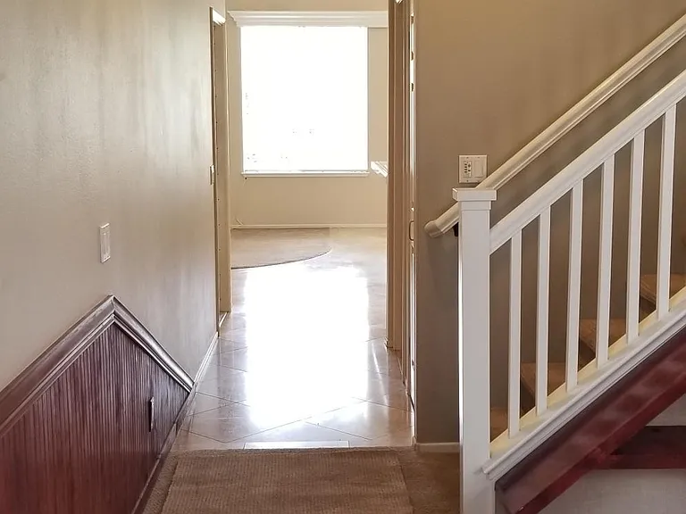 View of downstairs hallway towards the family room, kitchen, and dining room