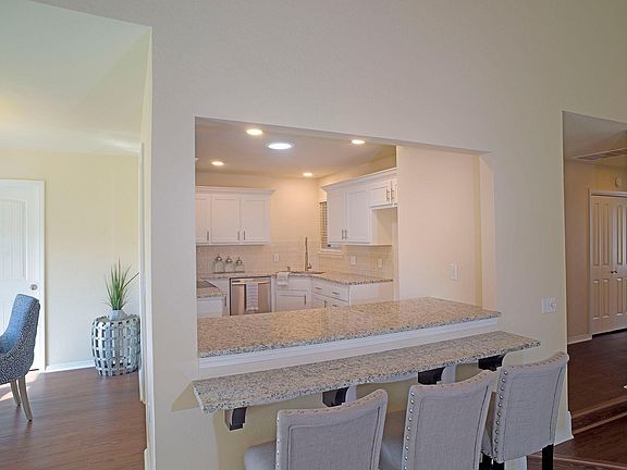 Cut out wall with bar counter. There is a sunlight (solar tube) in the kitchen so the lights don't need to be on during the day. There is a Samsung stainless steel refrigerator that is now in the kitchen with a bottom drawer freezer.